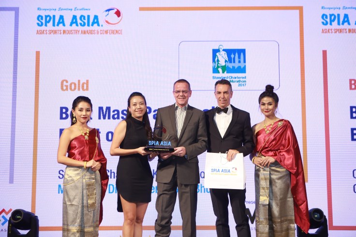 L-R Gloria Ng and Rainer Biemans, Directors of Dirigo Events with the Gold Award for Best Mass Participation Event, with Christopher Robb, CEO, Mass Participation Asia